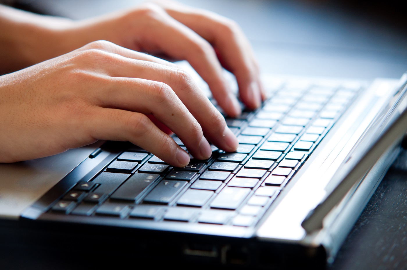 como escrever um e-mail marketing Imagem: uma mão digitando no teclado do notebook