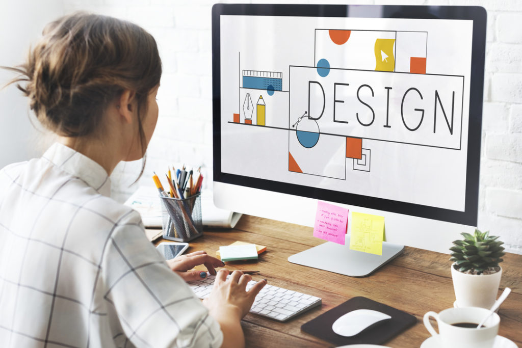 Imagem mostra mulher usando o computador para criar elementos de design.