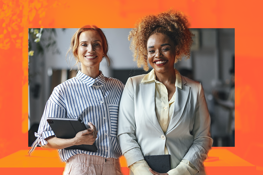 Duas mulheres sorrindo em roupas corporativas