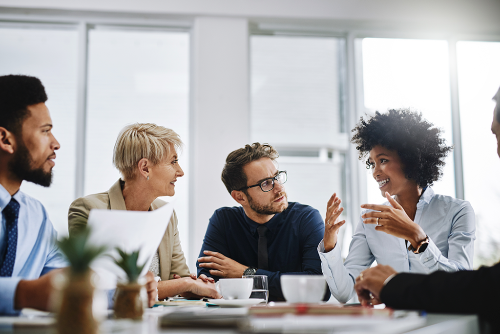 Equipe discutindo ideias em uma reunião produtiva, exemplificando comunicação assertiva no trabalho em equipe.