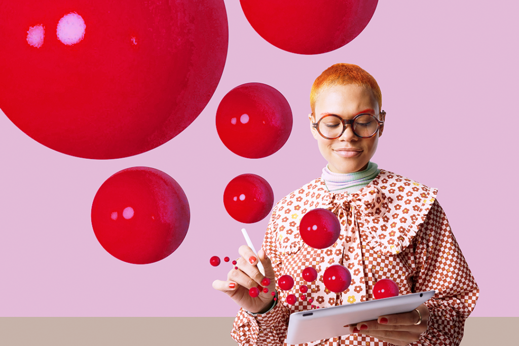 Mulher ruiva, usando uma roupa estampada vermelho e branco, escrevendo em um caderno e com bolas vermelhas ao redor