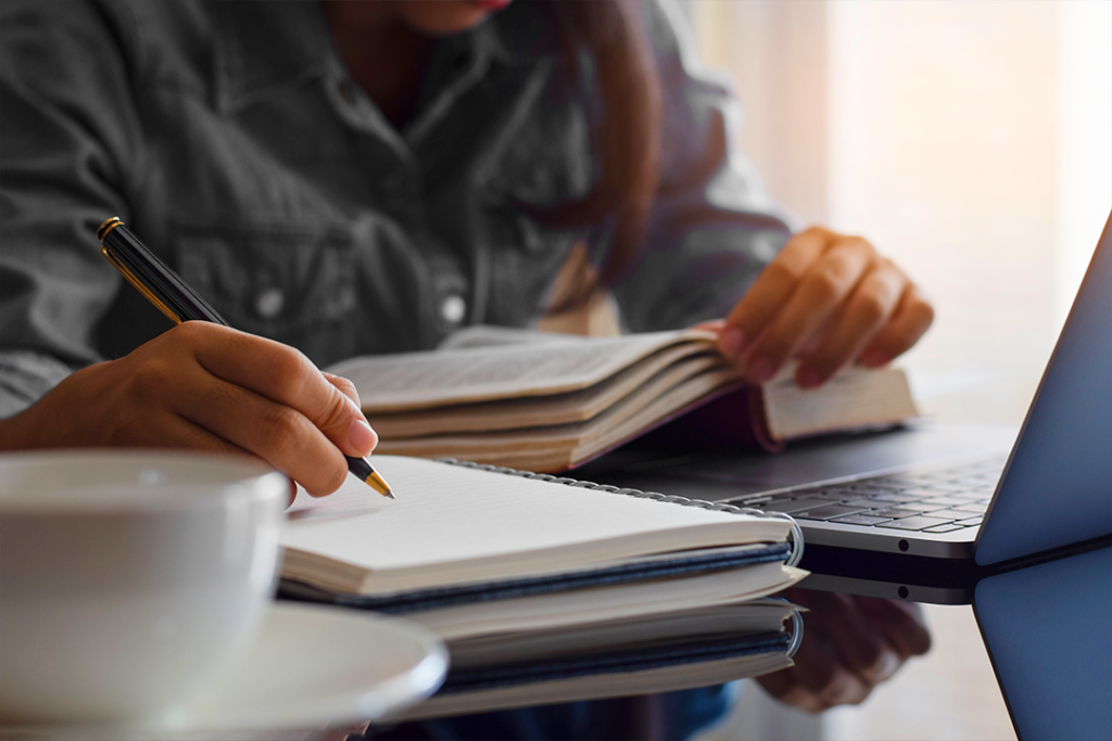 Pessoa estudando livros sobre oratória com foco em aprimorar habilidades de apresentação.