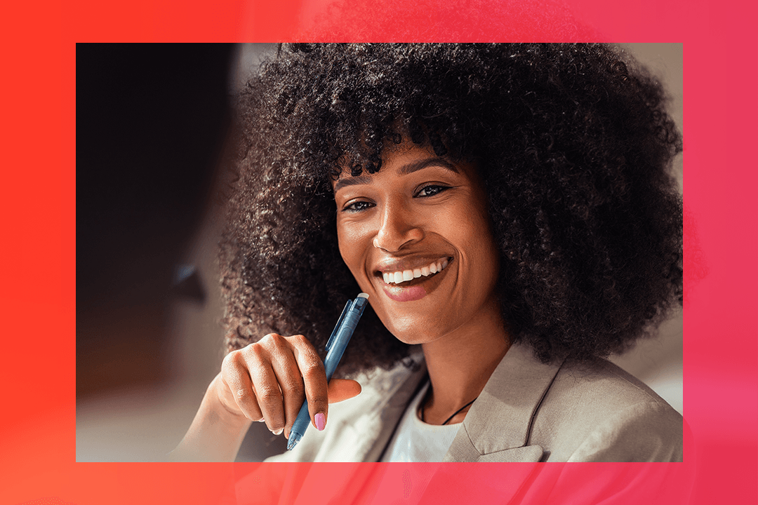 Mulher executiva sorri e segura uma caneta ao fazer um Elevator Pitch para líderes
