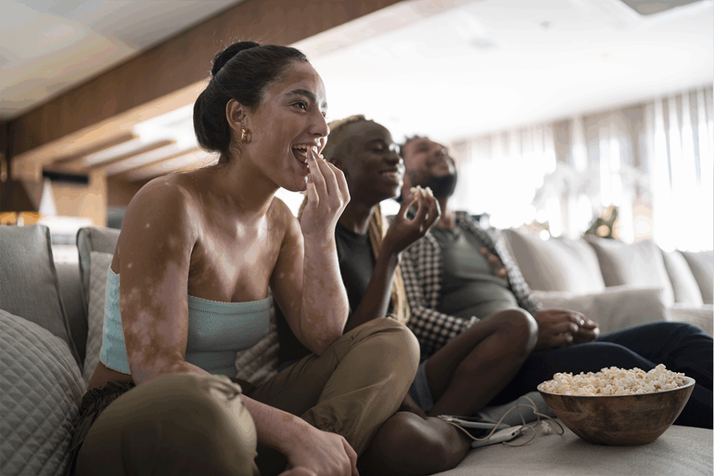 Amigos comendo pipoca e assistente a filmes da lista de melhores do século 21