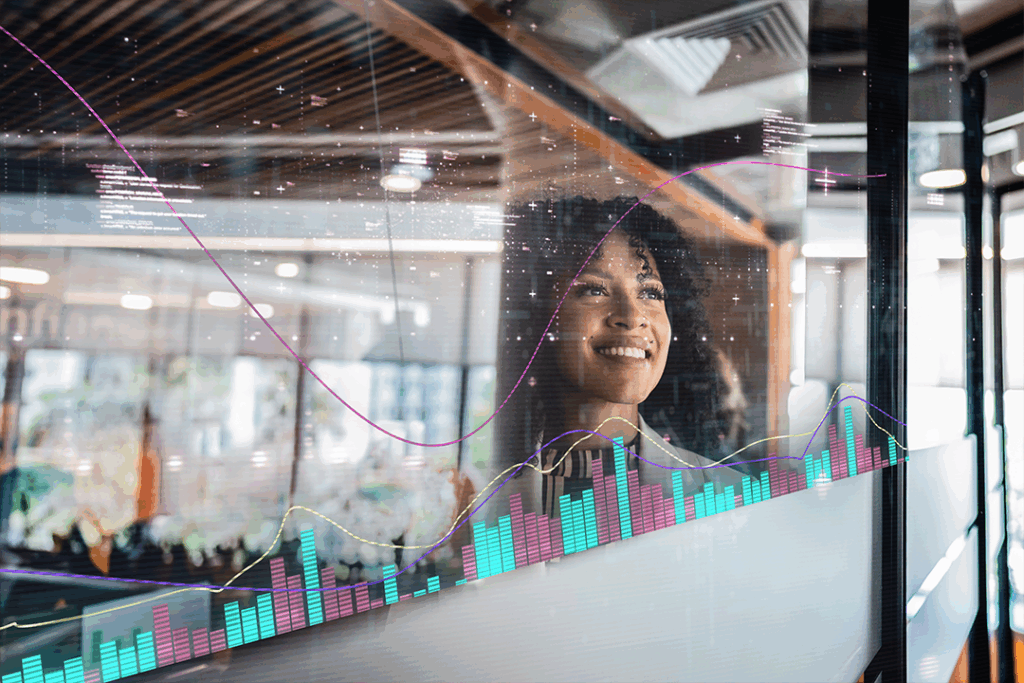 Mulher sorri olhando para um gráfico durante apresentação