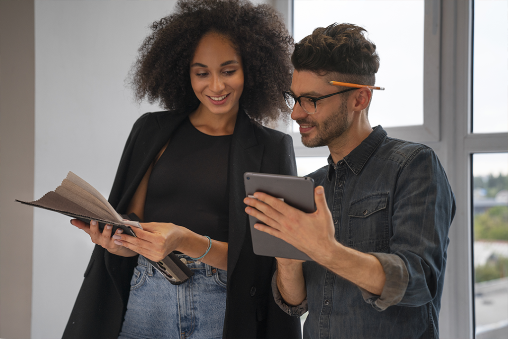 Duas pessoas em um escritório observando um tablet, discutindo sobre comunicação na era da IA.